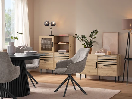 Esszimmer mit Esstisch, grauen Stühlen, einer Vitrine »BAAKEN« mit Glastür, einem Regal »BAAKEN« mit Schubladen und einem Sideboard mit Schubladen.