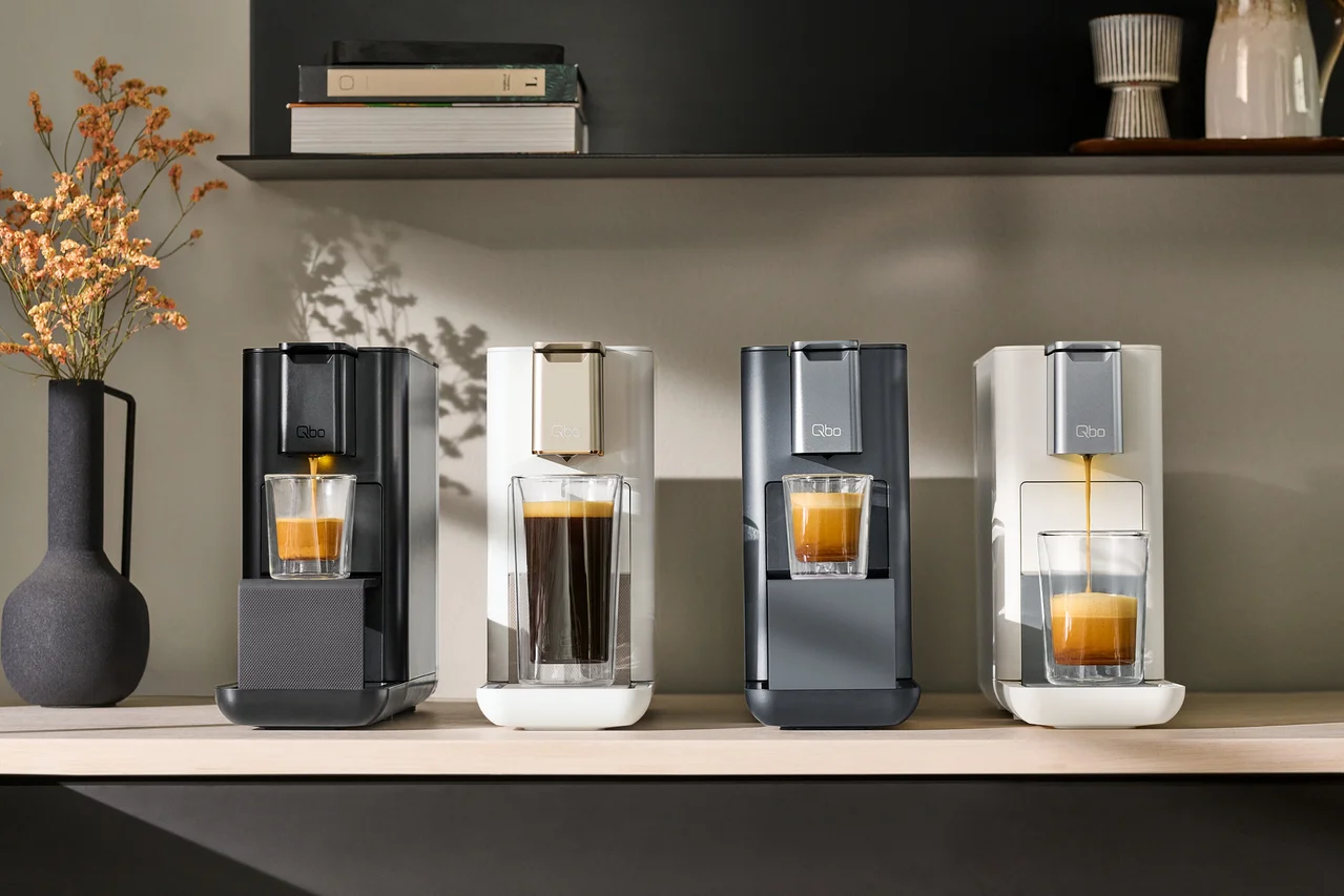 Vier Kaffeemaschinen stehen auf einem Regal nebeneinander.