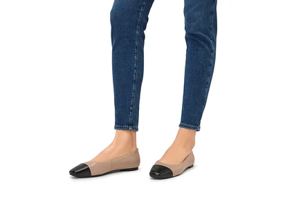 Beine in Jeans und Leder-Ballerinas.