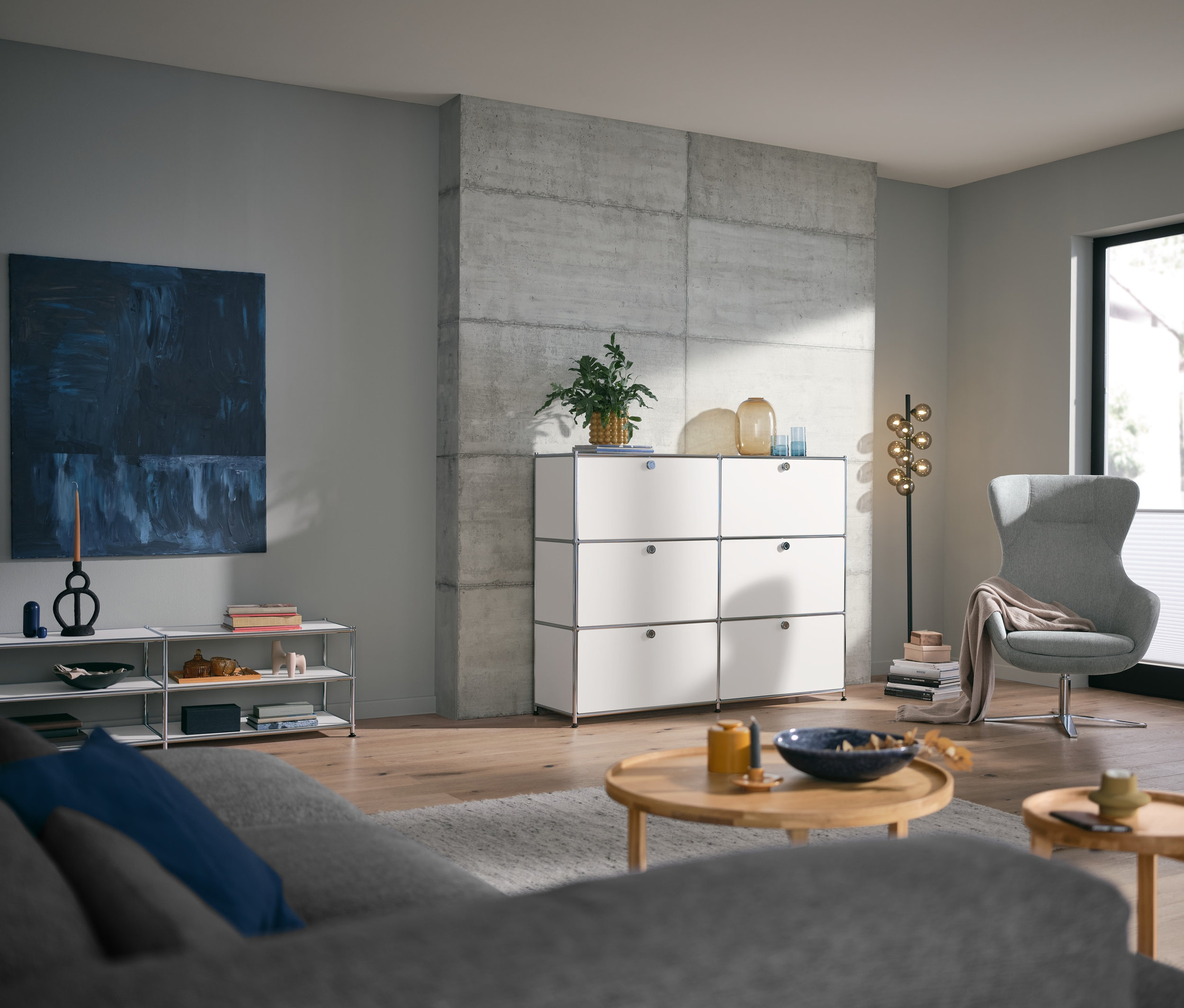 Wohnzimmer mit rundem Couchtisch und weißem Lowboard Metall »CN3« offen, sowie Metall Kommode »CN3« mit 6 Klappenfächern.