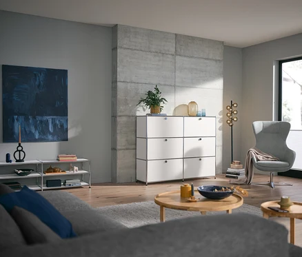 Wohnzimmer mit rundem Couchtisch und weißem Lowboard Metall »CN3« offen, sowie Metall Kommode »CN3« mit 6 Klappenfächern.
