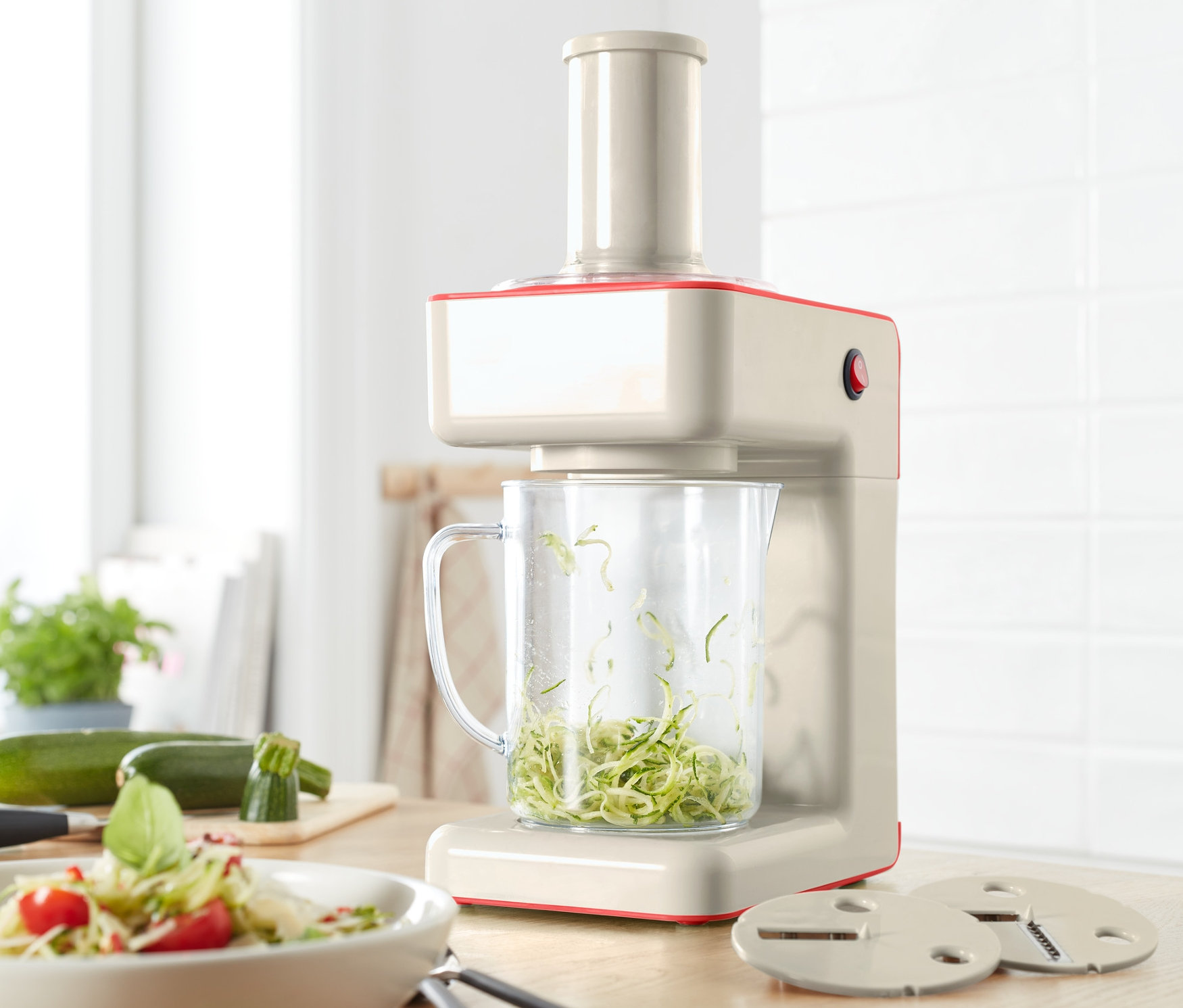 Elektrischer Spiralschneider mit geschnittenen Zucchini in einem Behälter.