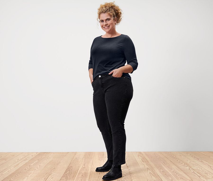 Frau posiert in einem dunkelblauen Shirt mit 3/4-Arm.