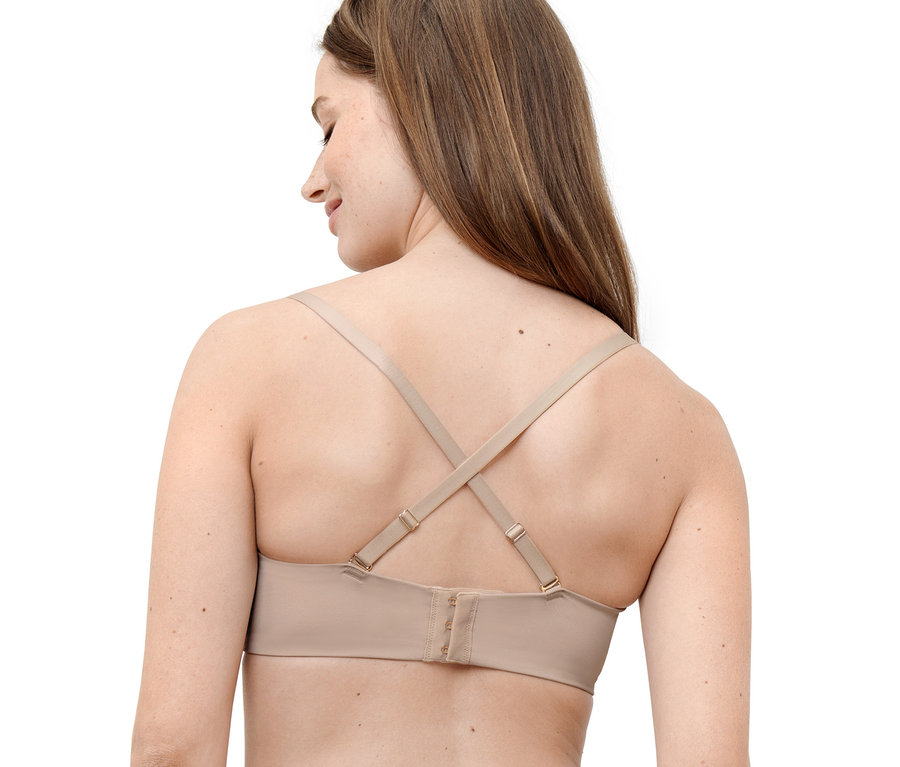 Frau trägt einen hautfarbenen Multistyle-BH, dessen Träger am Rücken gekreuzt sind.