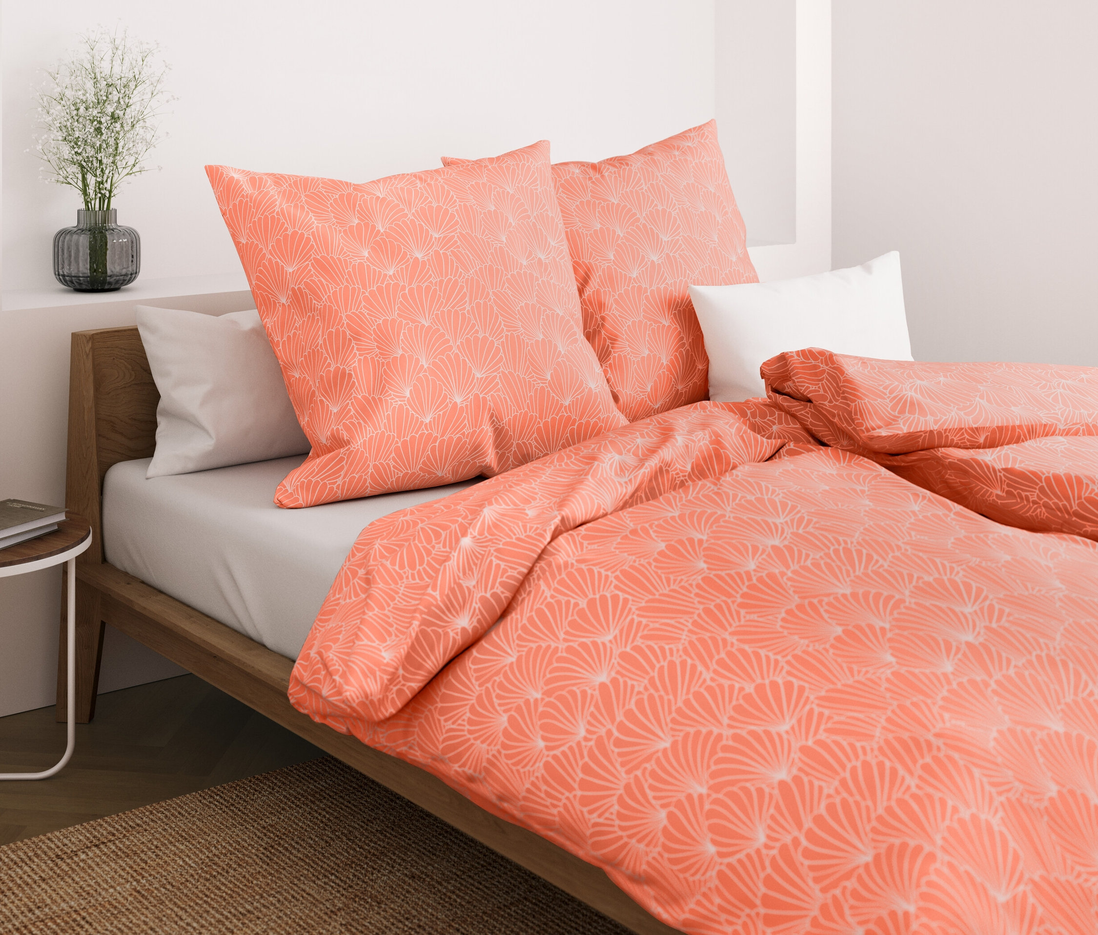 Nahaufnahme eines Bettes mit korallenfarbener Mikrofaser-Bettwäsche mit Muscheln, Normalgröße und Übergröße.