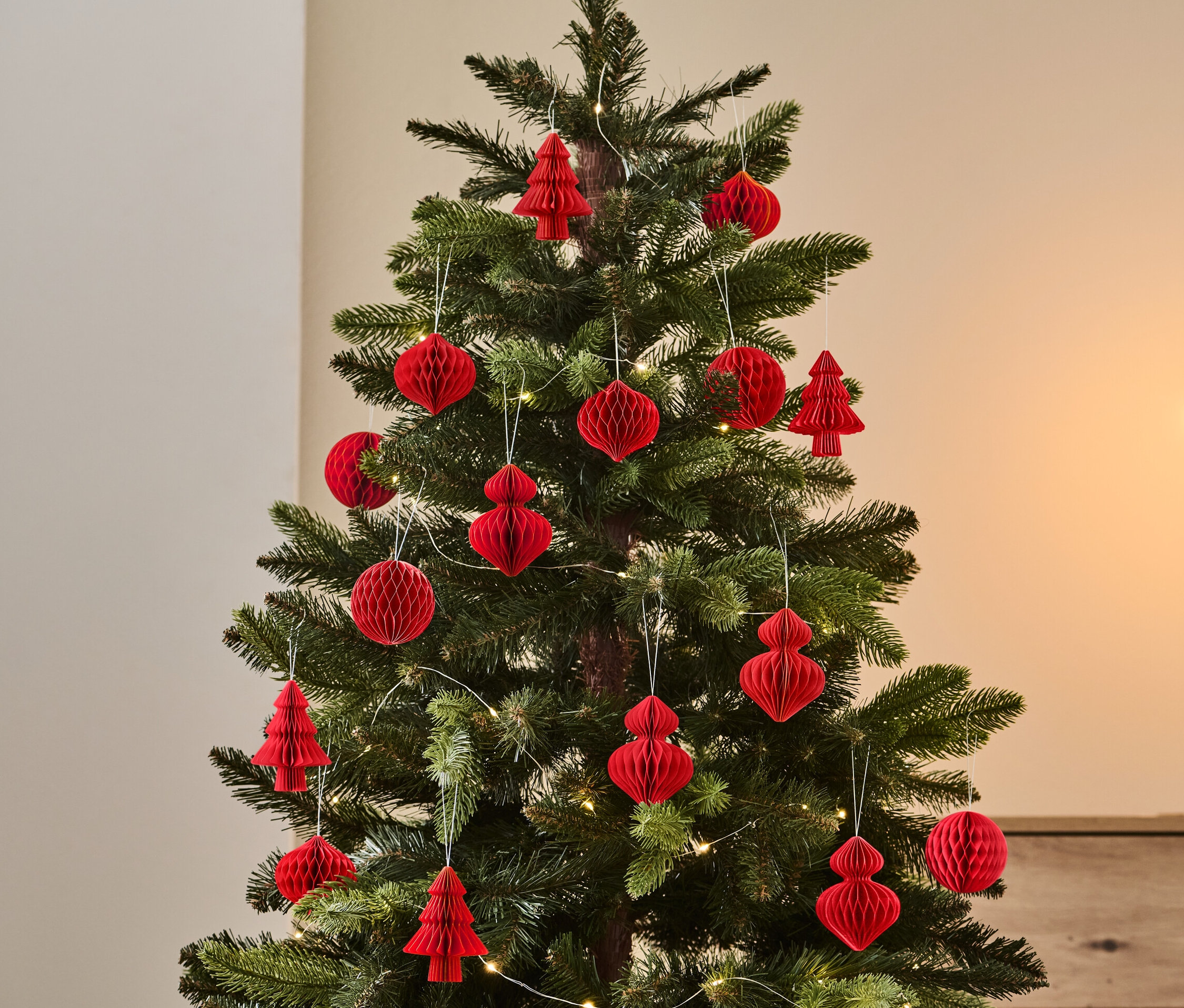 Weihnachtsbaum geschmückt mit einem 4er-Set rotem Weihnachtsschmuck.