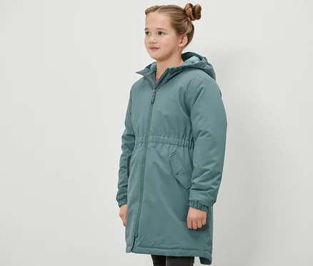 Mädchen steht seitlich und trägt eine grüne Kinder-Thermoparka.