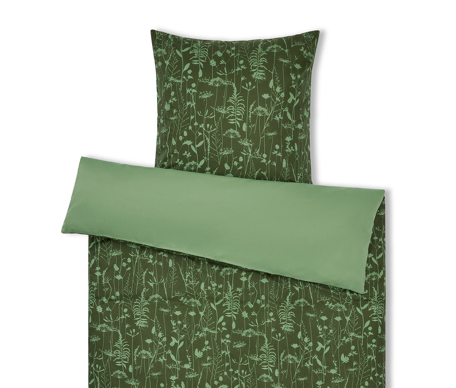 Grüne Bettwäsche mit Pflanzenmuster und hellgrünes Kissen.