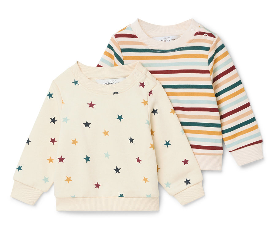 Zwei Kinderpullover liegen nebeneinander. Einer ist cremefarben mit Sternen und der andere ist gestreift.