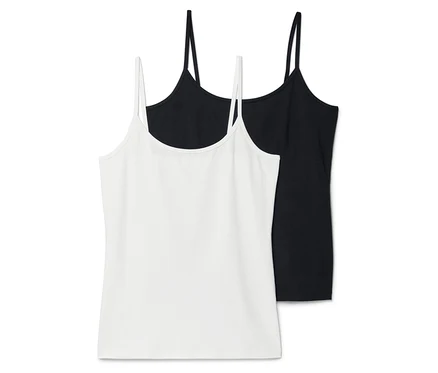 Zwei Tanktops, eines weiß und eines schwarz, liegen übereinander.