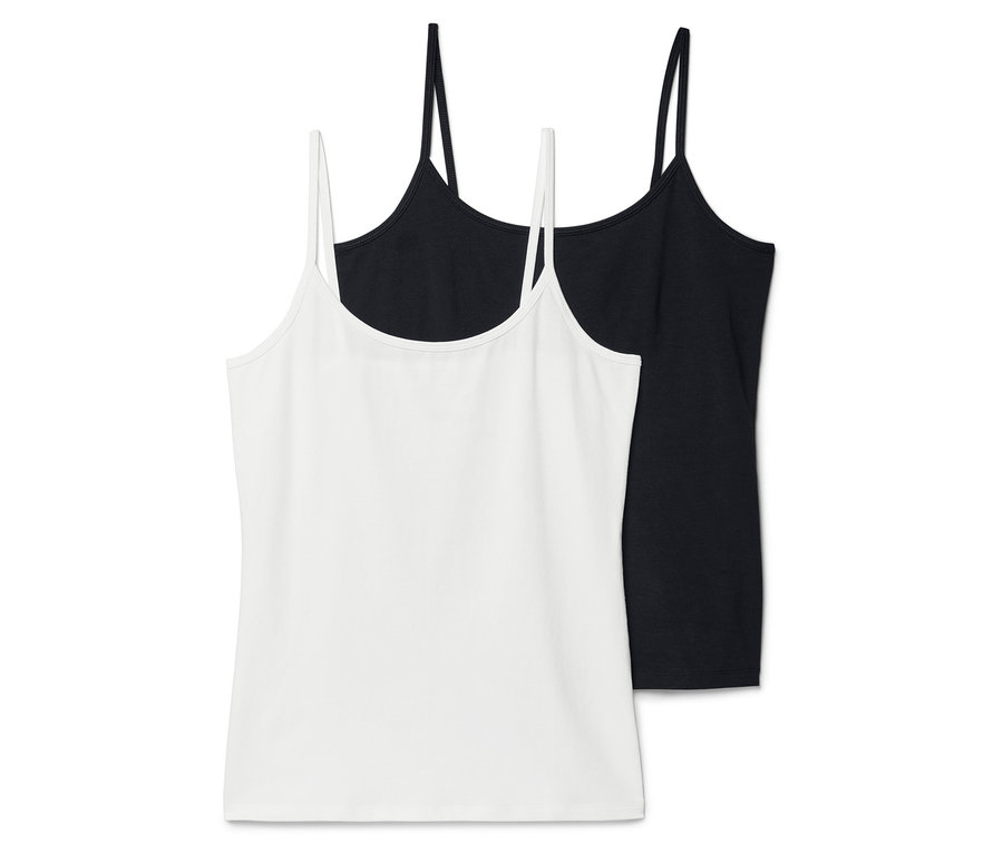Zwei Tanktops, eines weiß und eines schwarz, liegen übereinander.