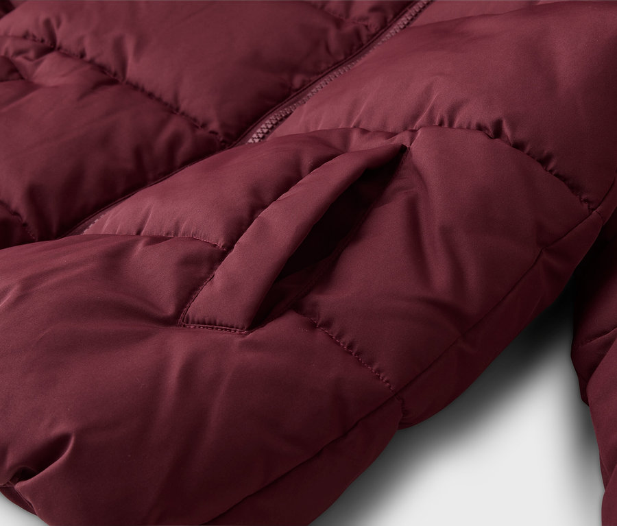 Nahaufnahme einer bordeauxroten Steppjacke, die ihre gesteppte Textur, einen teilweise sichtbaren Reißverschluss und eine Seitentasche zeigt.