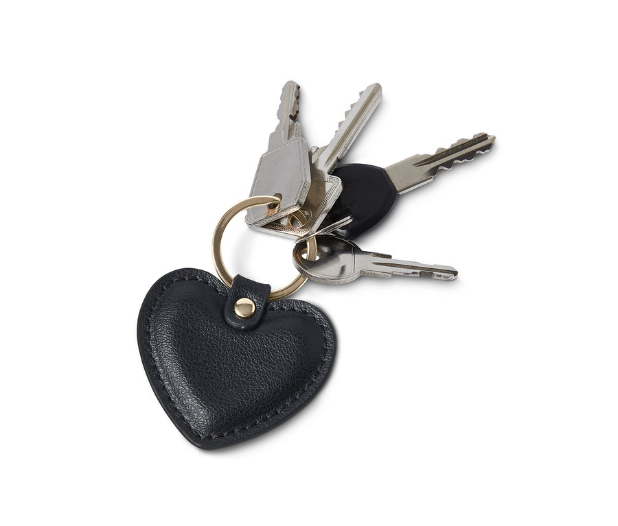 Vier Schlüssel an goldenem Ring mit schwarzem Schlüsselanhänger in Herzform.