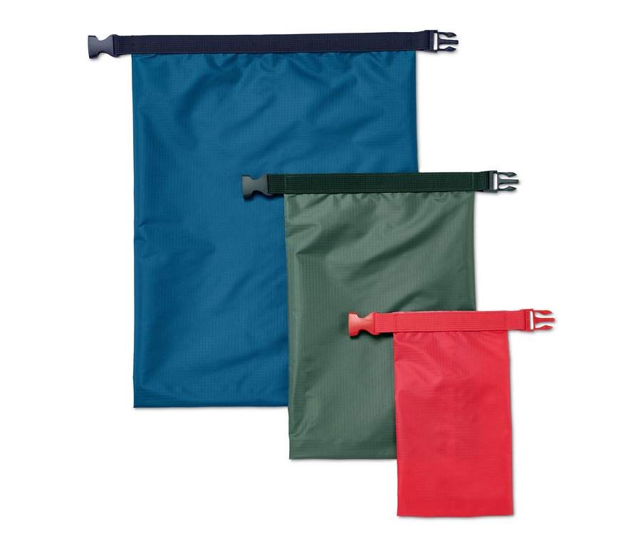 Drei wasserfeste Packsäcke in Blau, Grün und Rot.