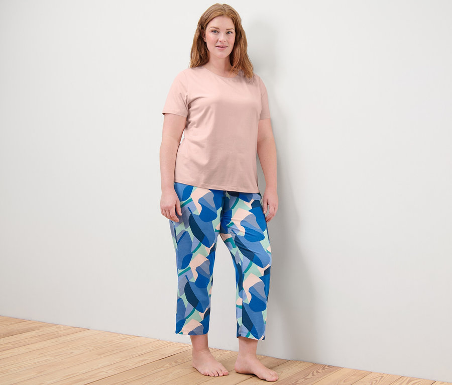 Frau steht und trägt einen Pyjama.