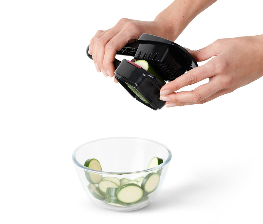 Hände schneiden mit dem Nicer Dicer Quick Gemüse über einer Schüssel.
