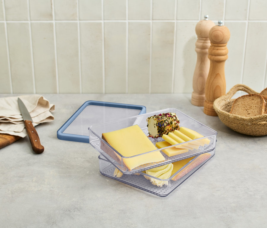 Aufschnittbox mit Käse und Wurst auf einem Tisch.