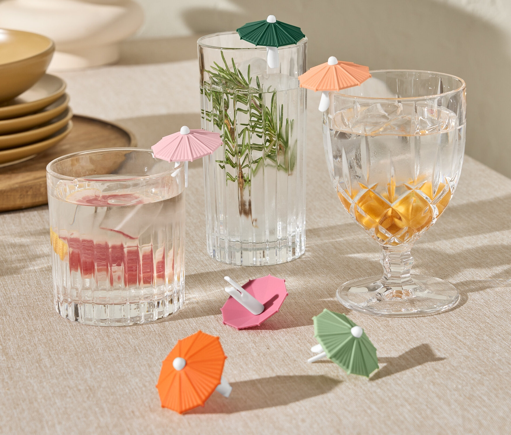 Gläser mit Getränken und dekorativen Schirmchen und 6 Glas-Markierer.