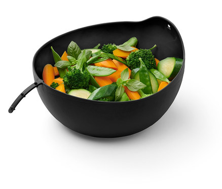 In einer Schüssel befinden sich geschnittene Karotten, Brokkoli, Zucchini, grüne Erbsen und Basilikum.