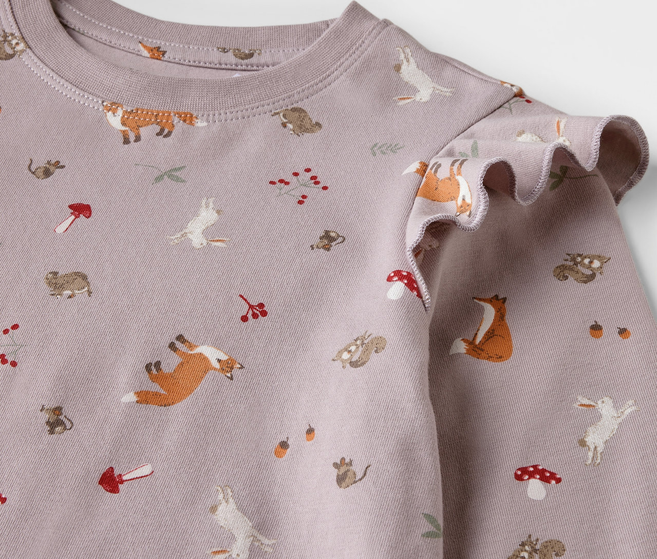 Detailansicht eines Kinder-Nachthemds mit Fuchs-, Hasen-, Eichhörnchen- und Pilzprint.