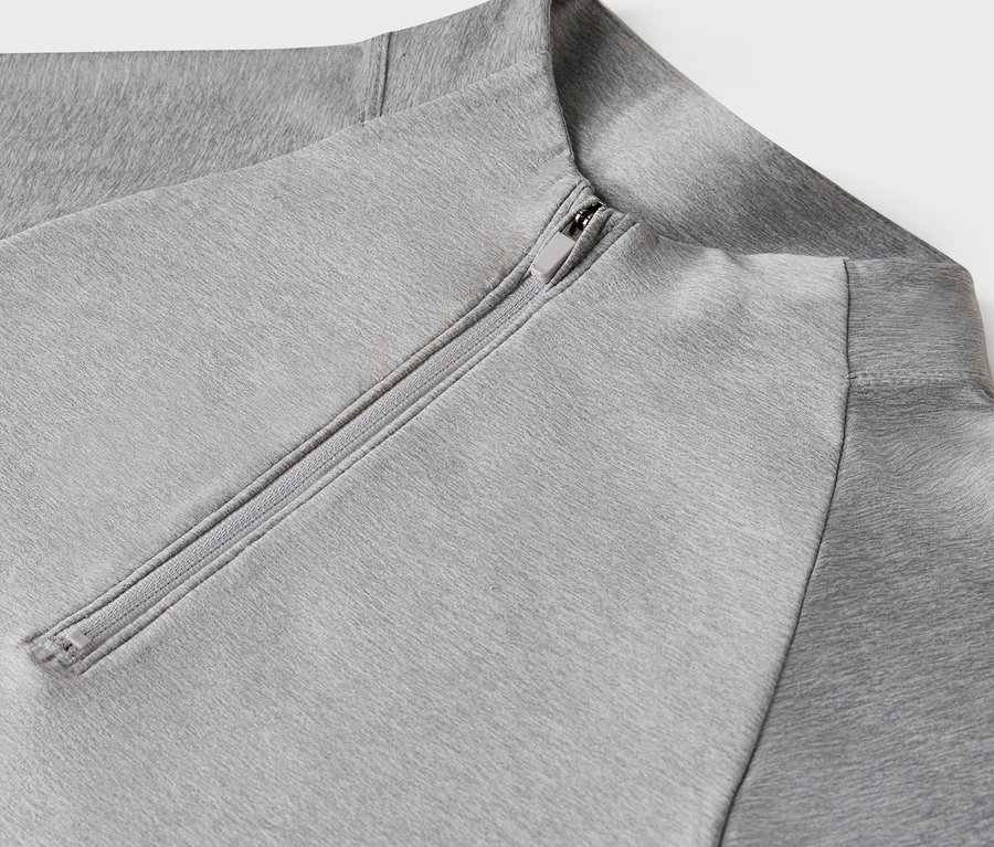 Detailaufnahme eines hellgrauen Sweatshirts mit Reißverschluss.