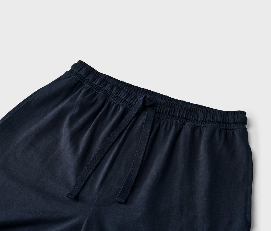 Detailaufnahme einer marineblauen Trainingshose mit Kordelzug in der Taille.