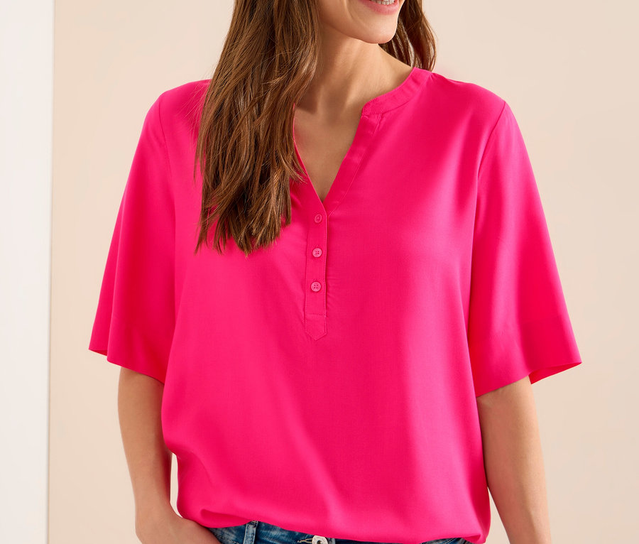 Frau mit Jeans trägt eine pinke CECIL Tunikabluse.