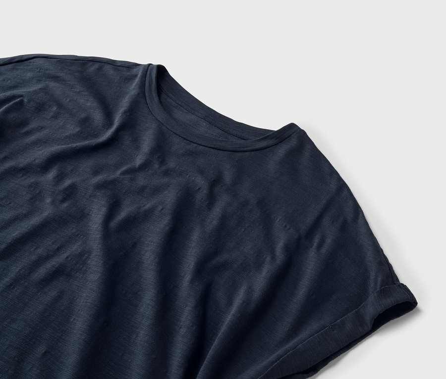 Nahaufnahme eines marineblauen T-Shirts auf weißem Hintergrund.