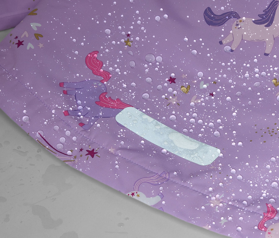 Nahaufnahme eines lila Stoffes mit Einhornmuster, Wassertropfen und einem reflektierenden Streifen.