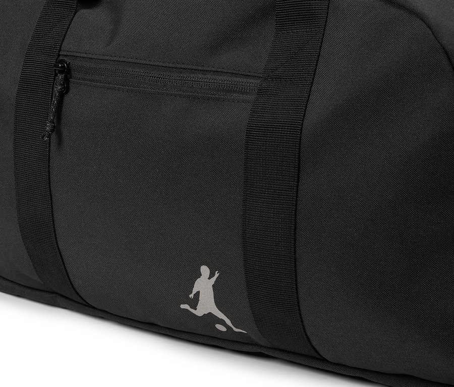 Nahaufnahme einer schwarzen Sporttasche mit Reißverschlusstasche und Logo einer Fußball spielenden Person.
