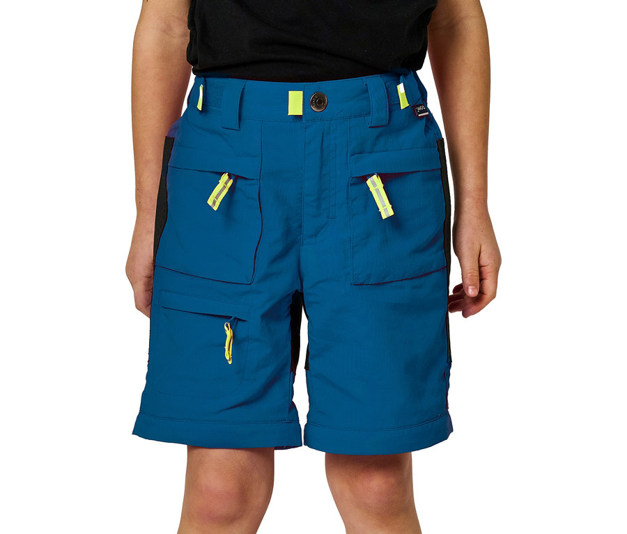 Kind trägt blaue Shorts mit mehreren Taschen und gelben Akzenten.