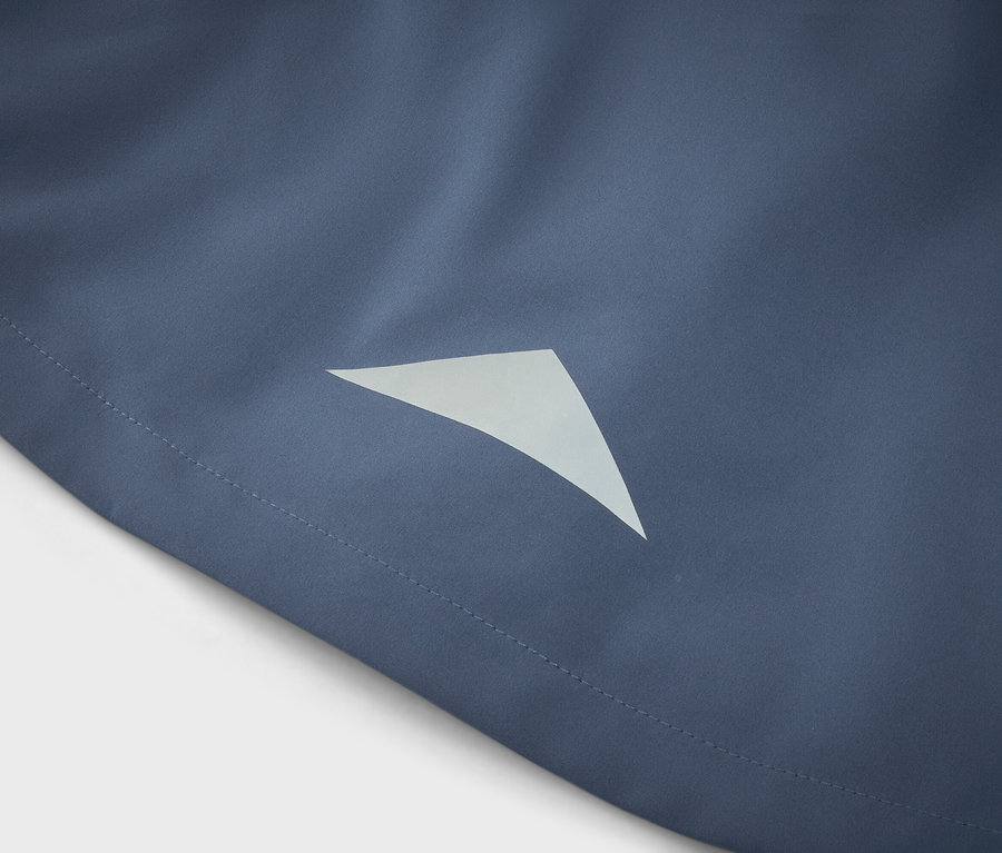 Nahaufnahme eines blauen Stoffes mit einem dreieckigen, reflektierenden Detail.