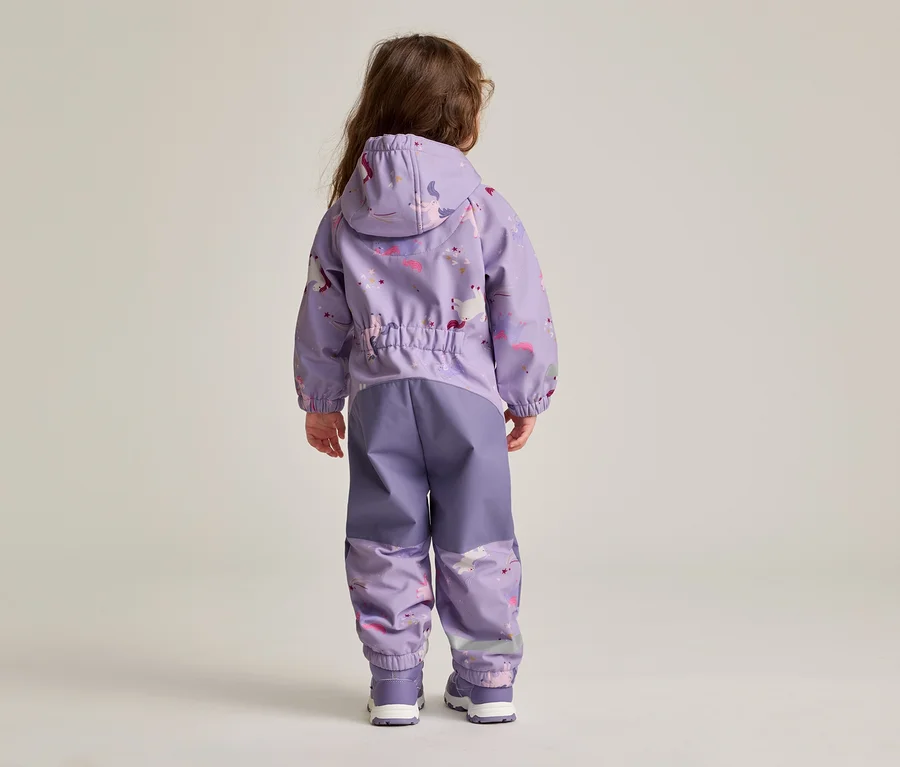 Rückansicht eines Kindes mit langen braunen Haaren, das eine lila Regenjacke mit Kapuze und passender Regenhose mit Einhornmuster trägt.