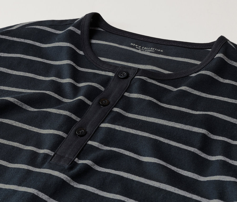Nahaufnahme eines dunkelblauen, langärmeligen Henley-Shirts mit grauen Streifen und drei Knöpfen.