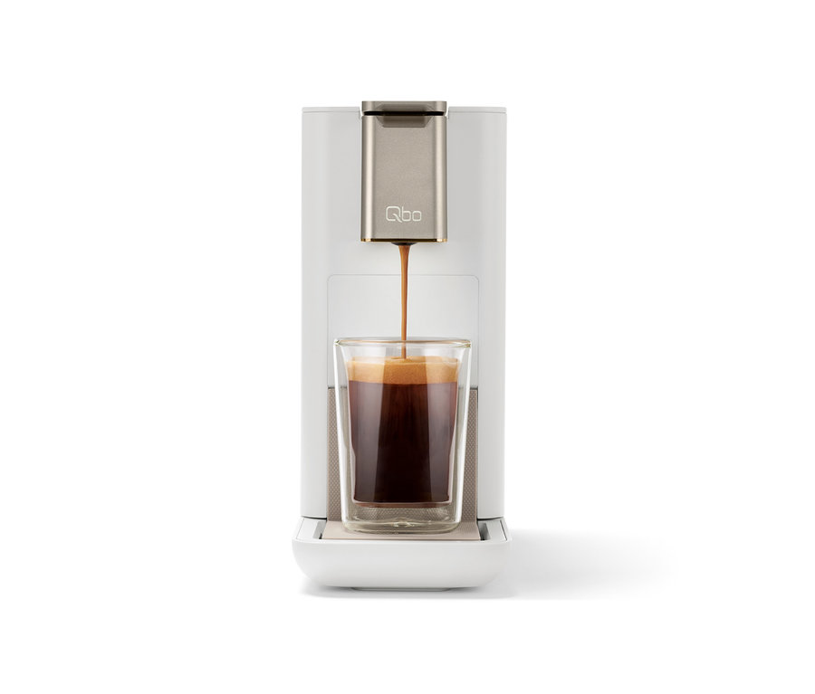 Kaffee fließt aus einer Kaffeemaschine in ein Glas.