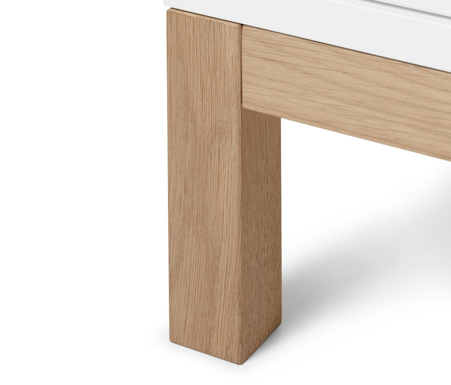 Detailansicht der Unterseite eines Highboards »Eklund« mit Schubladen, wobei das weiße Highboard auf hellen Holzbeinen steht.