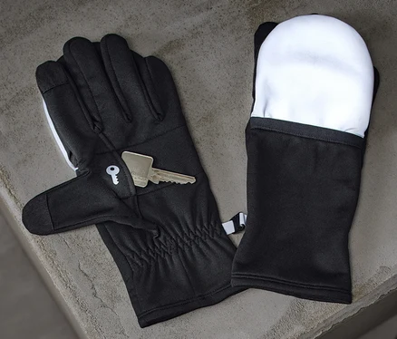 Schwarze Klapp-Laufhandschuhe und ein Schlüssel liegen auf einer grauen Betonfläche neben einer schwarzen Wasserflasche.