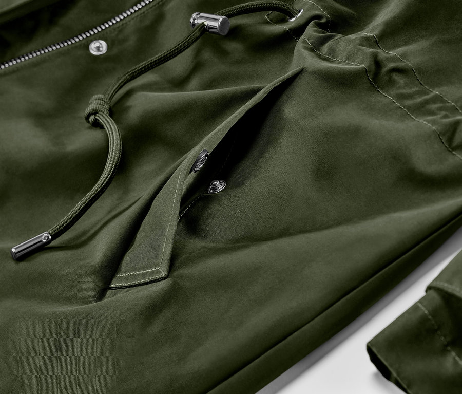 Detailansicht einer grünen Parka mit Kapuze, Kordelzug und Pattentasche mit Druckknöpfen.