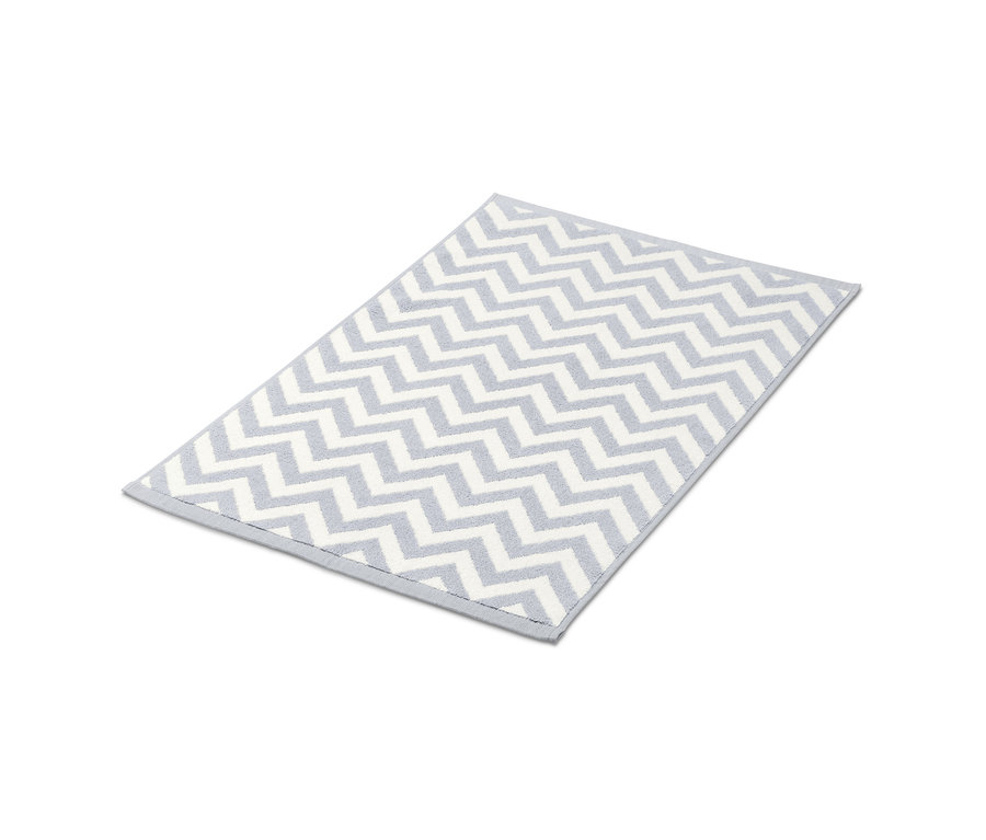 Grau-weißer Duschvorleger mit Zickzackmuster.