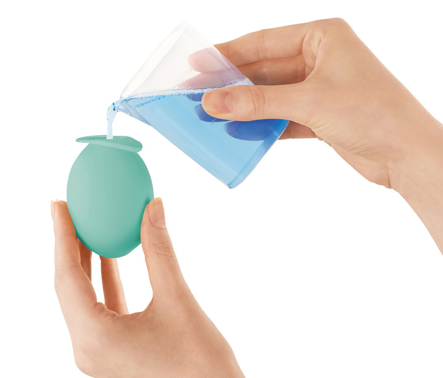 Frau gießt Flüssigkeit in einen Wasserhahn Entkalker-Aufsatz.