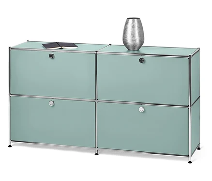 Ein hellblauer Schrank mit vier Türen. Obenauf liegen ein Buch und eine Vase.