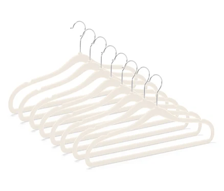 Sieben beige Samt-Kleiderbügel mit verchromten Haken, diagonal in der unteren rechten Ecke angeordnet.