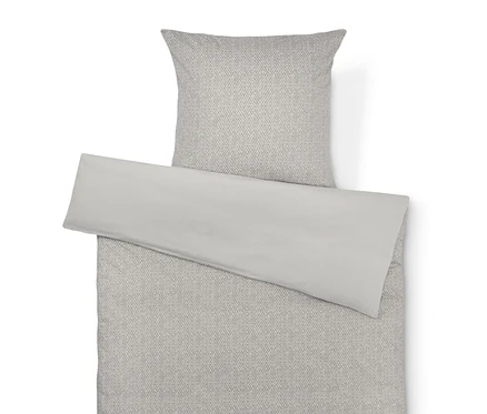 Beige Bettwäsche mit grauem Fischgrätenmuster und einfarbig beiger Kissenbezug.