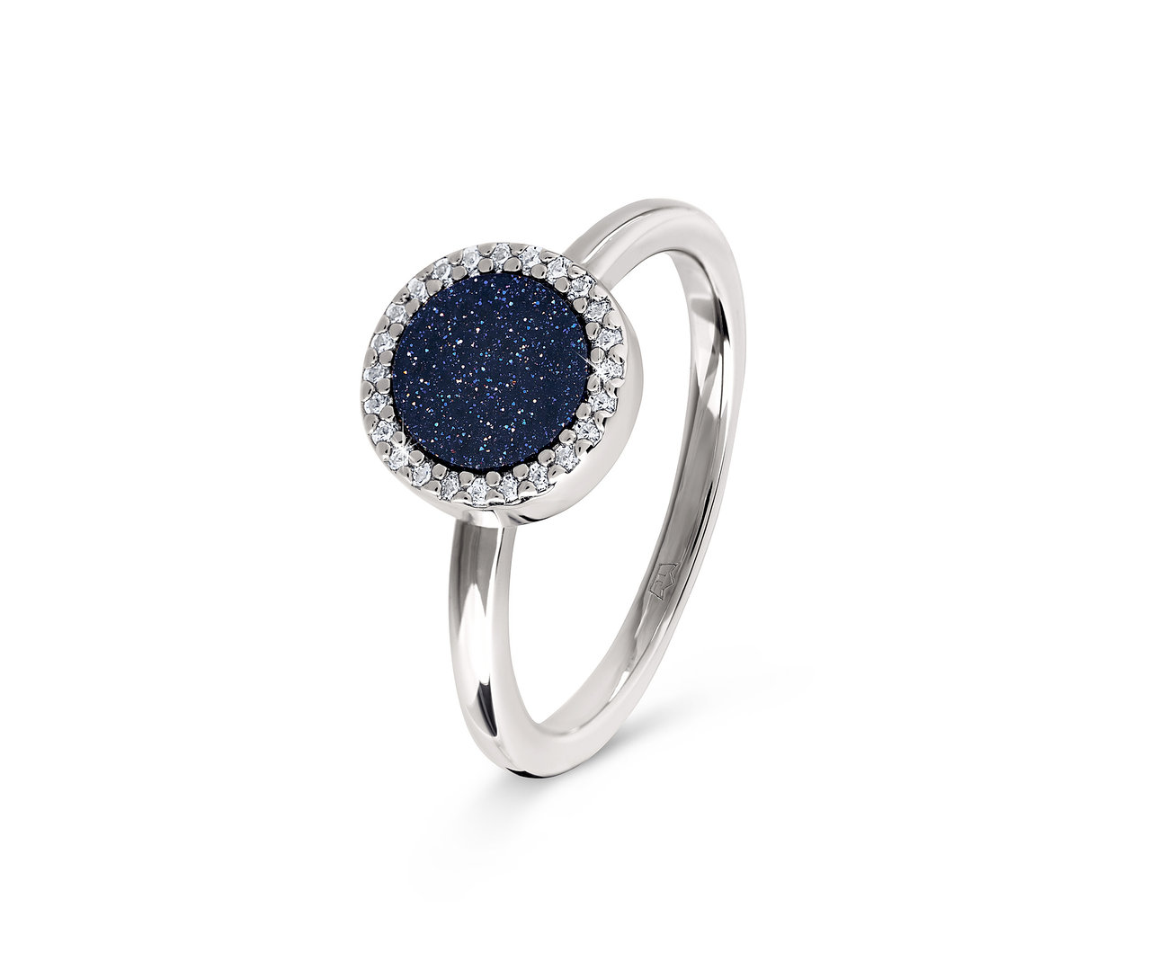 Detailaufnahme eines silbernen Rings mit einem dunkelblauen, runden Stein, der von klaren Steinen umgeben ist.