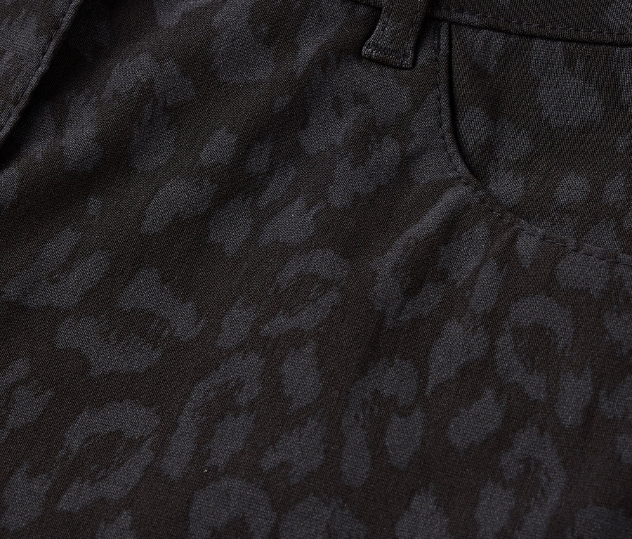 Detailaufnahme einer schwarzen Hose mit Leopardenmuster, inklusive Knopf und Tasche.