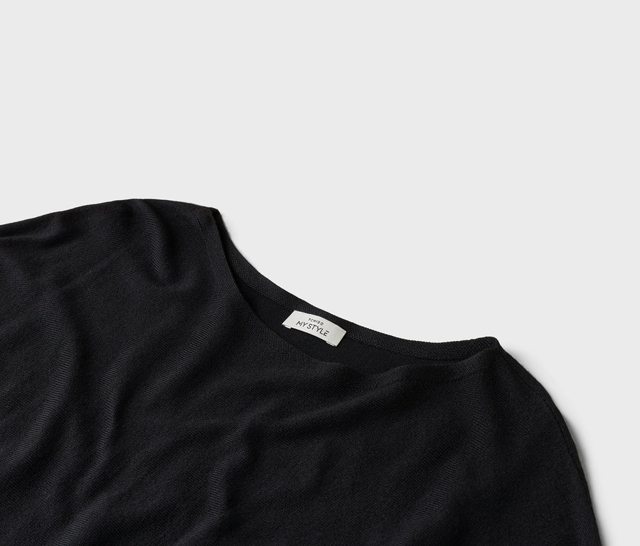 Nahaufnahme eines schwarzen T-Shirts mit einem Etikett, auf dem "TCHIBO MY STYLE" steht.