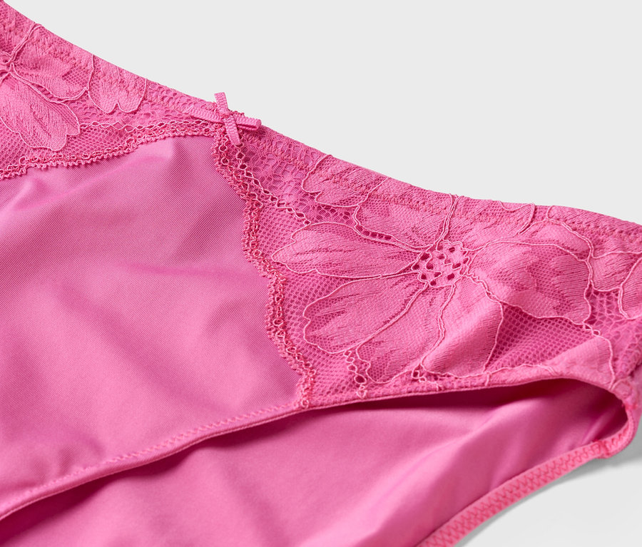 Nahaufnahme eines pinkfarbenen Slips mit floraler Spitze am Bund.