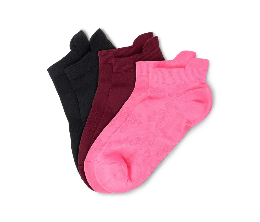 Drei Socken in Schwarz, Dunkelrot und Pink, aufgefächert auf weißem Hintergrund. Die pinke Socke hat ein dezentes Muster.