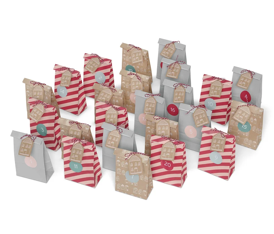 Aufgestellte Adventskalender-Tüten-Sets mit Zahlen und Hausdekorationen.
