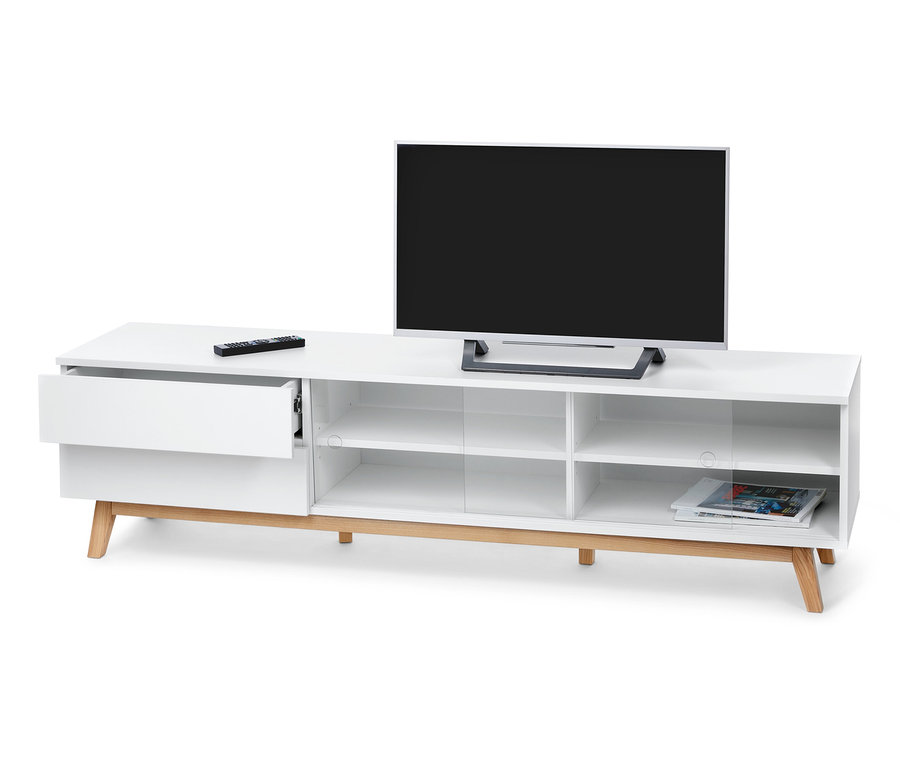 Fernseher steht auf weißem Lowboard mit Schiebetüren. Auf dem Lowboard liegt eine Fernbedienung.
